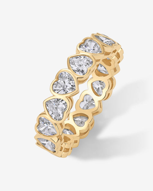A gold-tone eternity ring with clear heart-shaped stones shown from the side at an angle (PAVOI reference image; supplier appearance awaits verification)