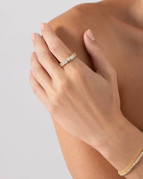 A gold-tone heart-stone eternity ring worn on a finger (PAVOI reference image; supplier appearance awaits verification)