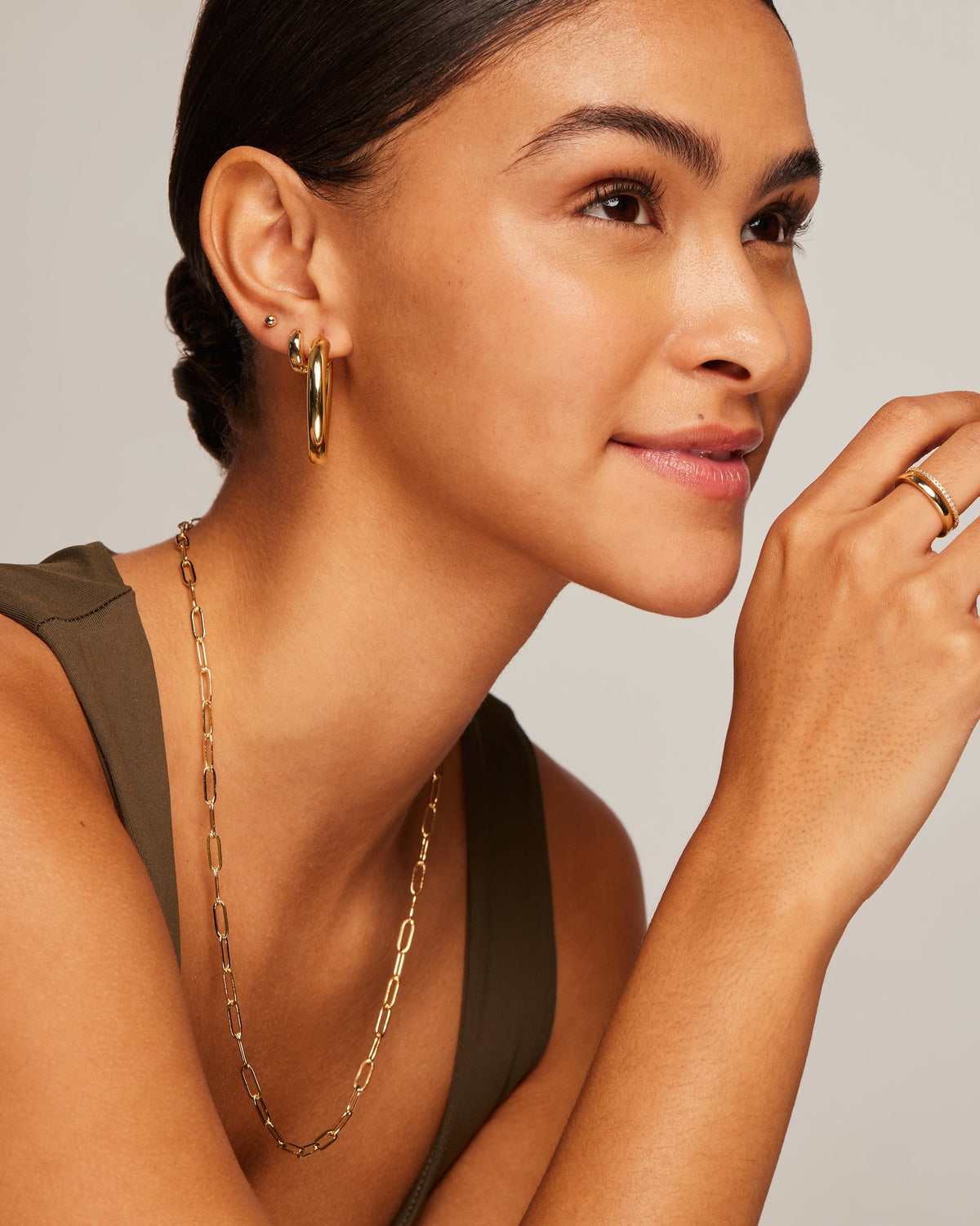 A gold-tone oval hoop earring worn on a model's ear (PAVOI reference image; supplier appearance awaits verification)