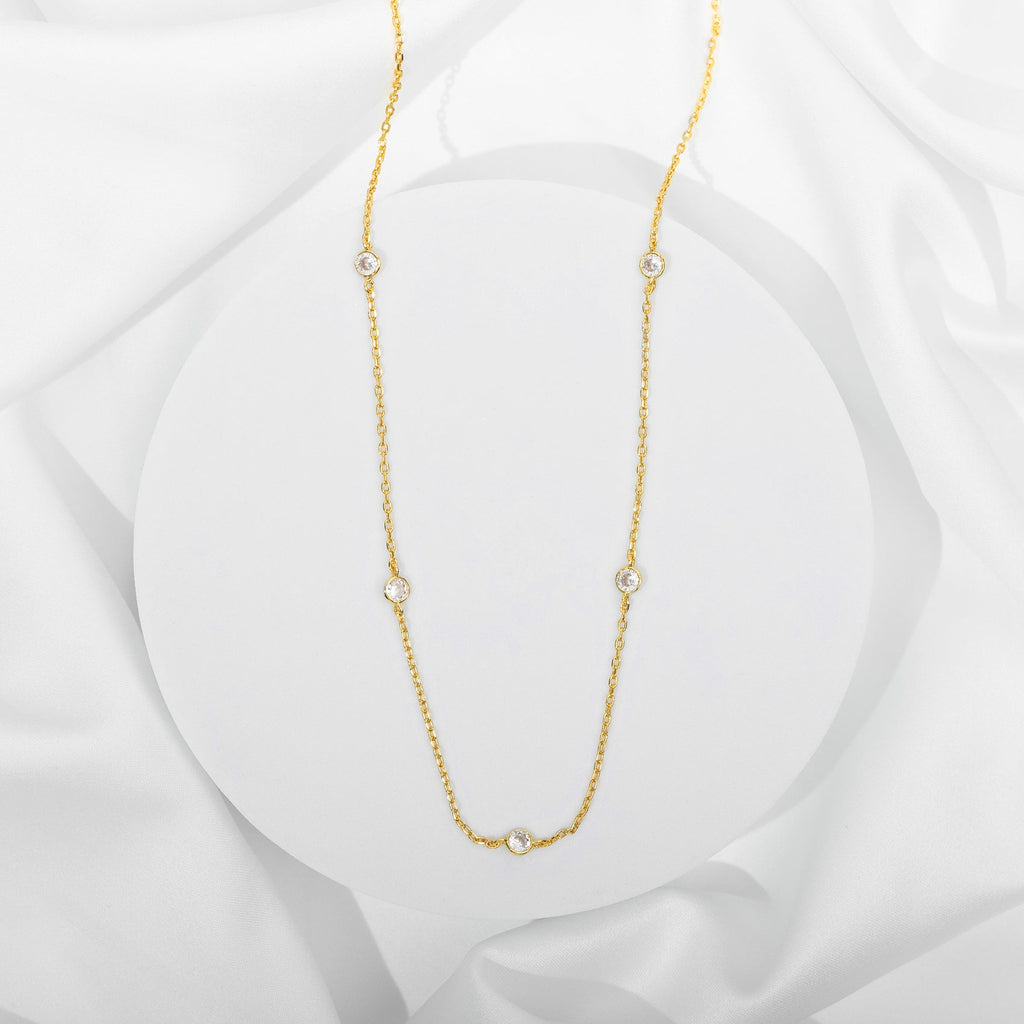 A gold-tone station necklace with round clear stones displayed on a white surface (PAVOI reference image; supplier appearance awaits verification)