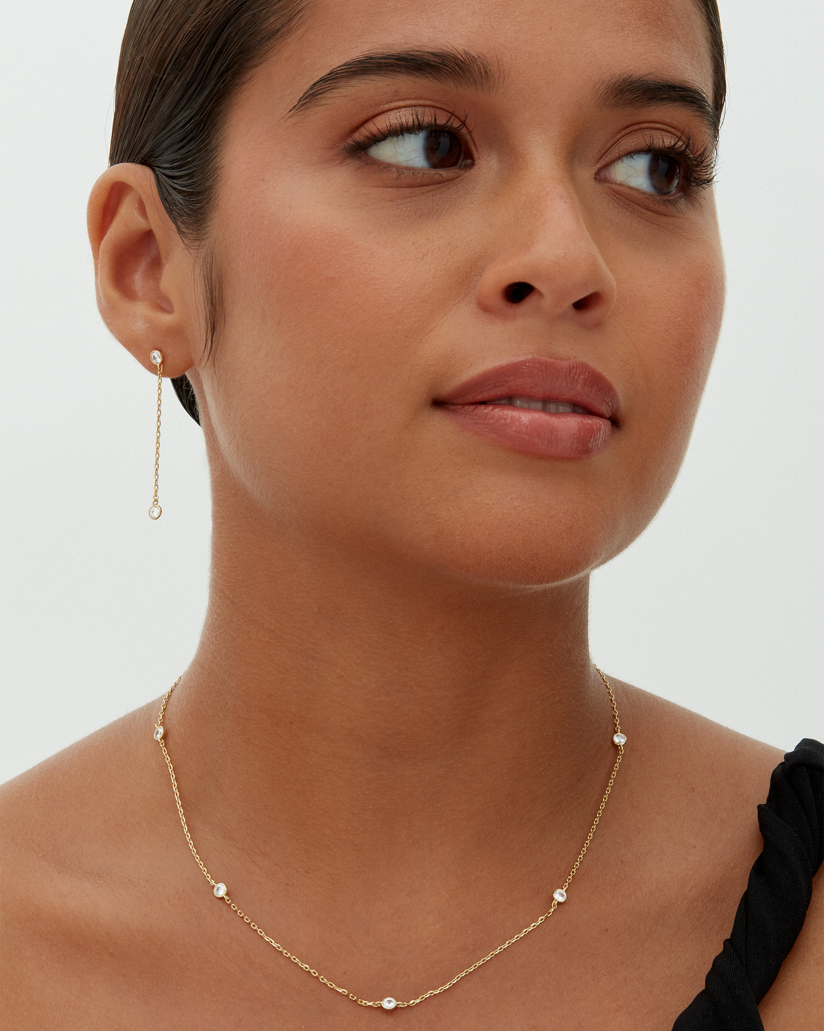 A gold-tone station necklace with round clear stones worn around a model's neck (PAVOI reference image; supplier appearance awaits verification)