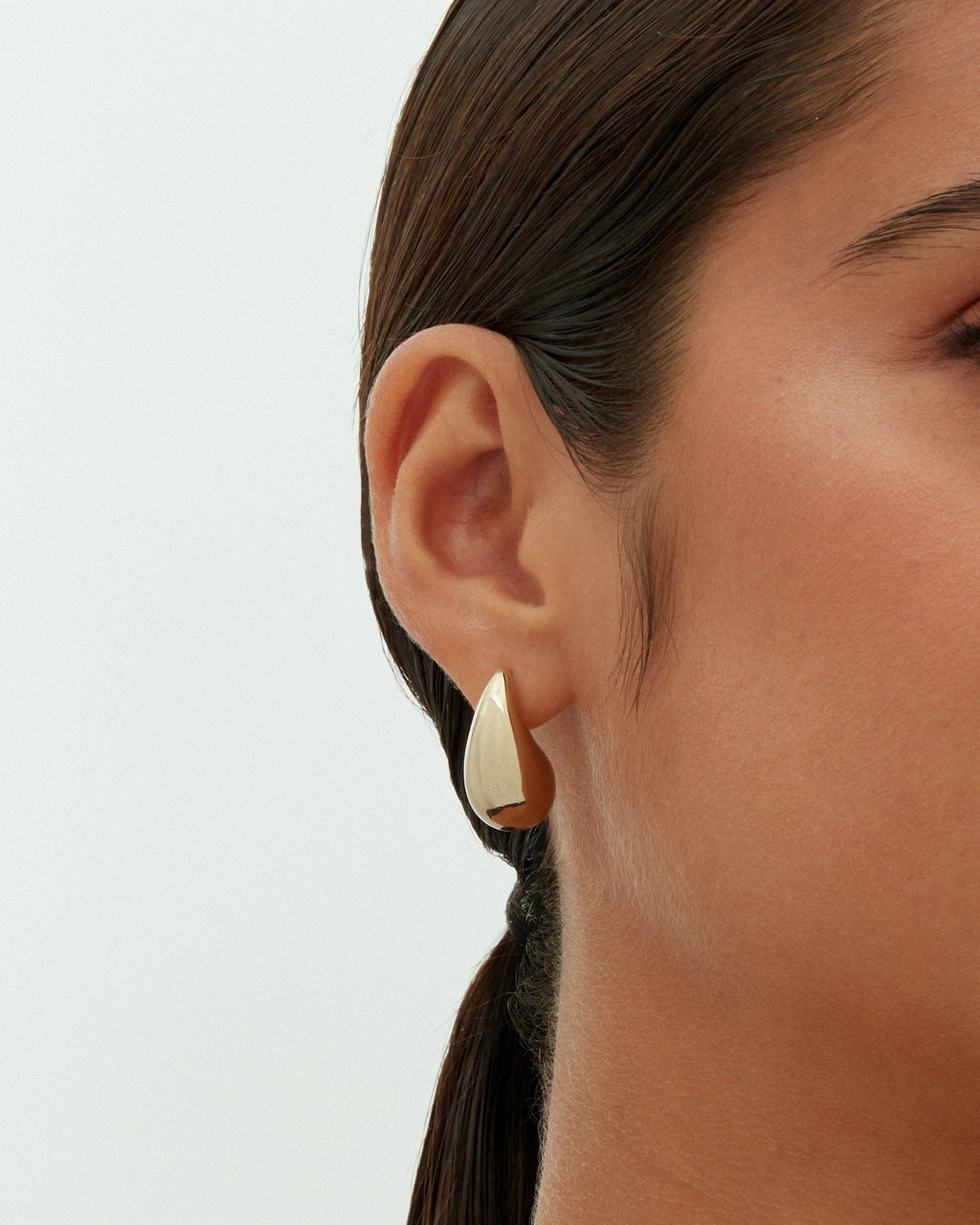 A gold-tone teardrop earring worn on a model's ear (PAVOI reference image; color illustration; supplier dimensions unverified)