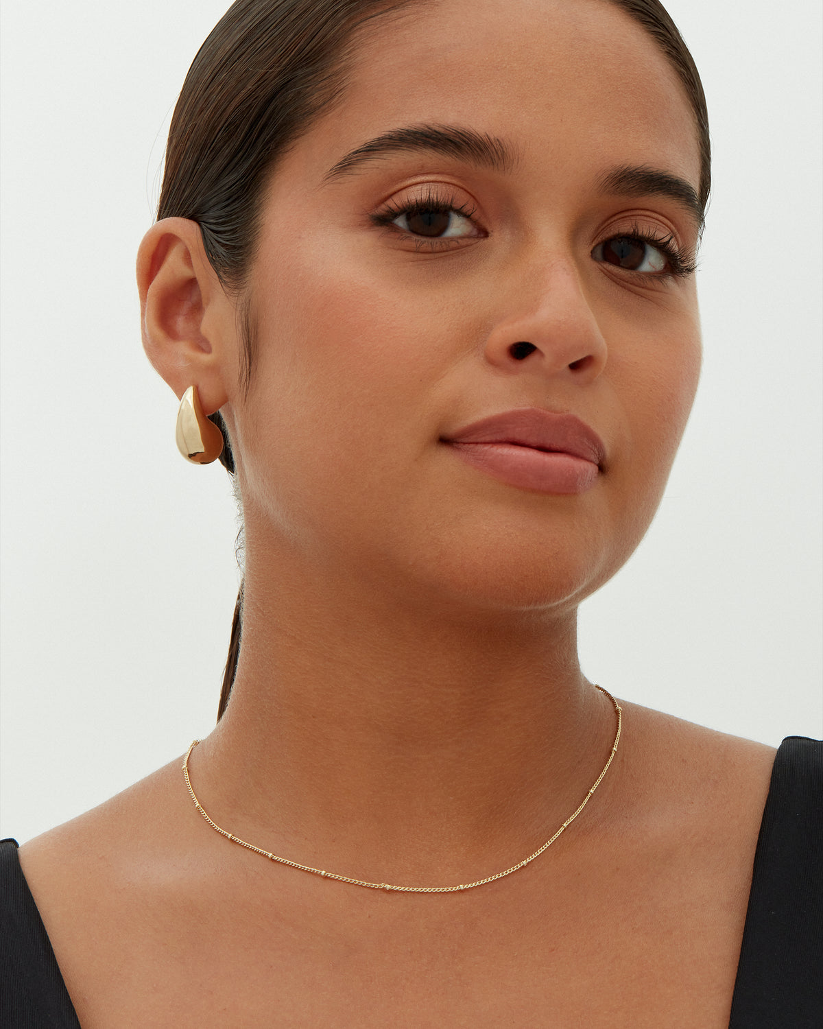 A gold-tone teardrop earring worn on a model's ear (PAVOI reference image; color illustration; supplier dimensions unverified)