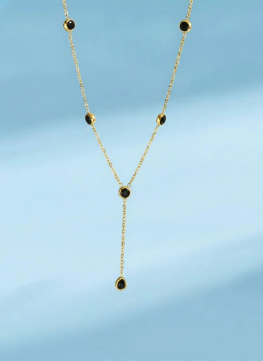 Gold-tone Y-necklace with black round stones and a teardrop pendant