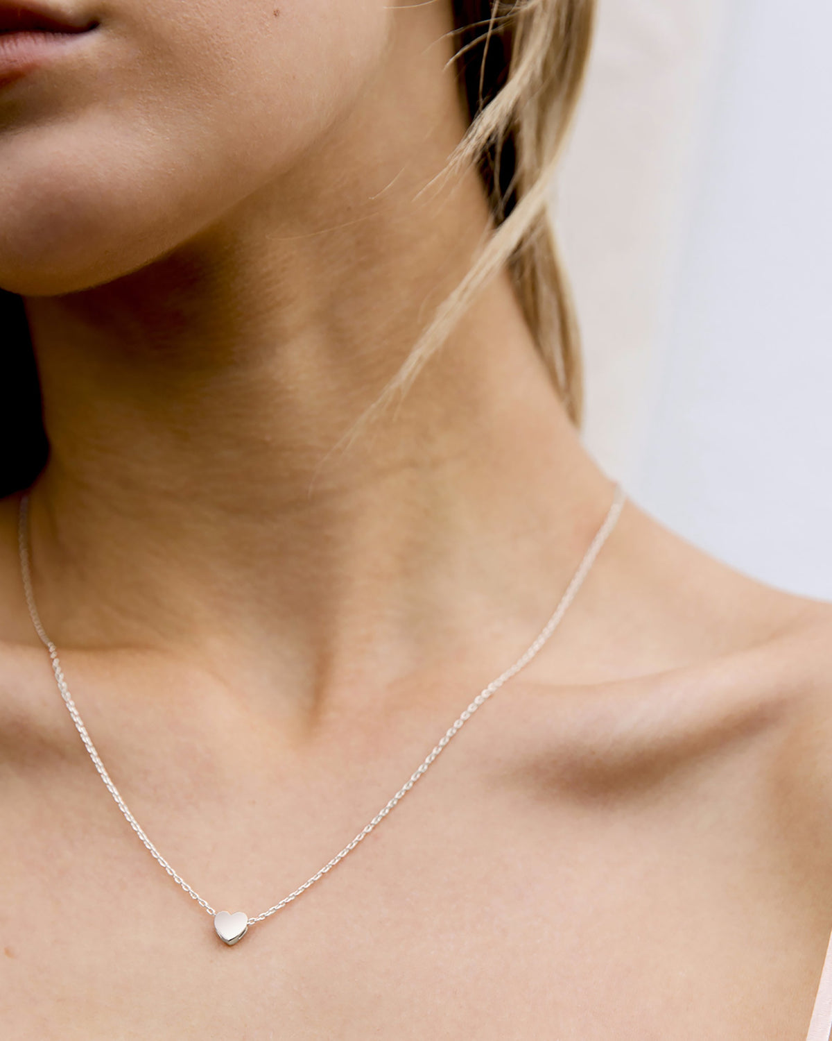A silver-tone heart pendant necklace worn at the collarbone (PAVOI reference image; supplier appearance awaits verification)